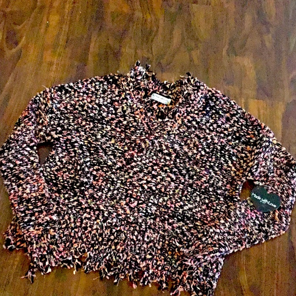 Multi-colored pinks and corals on black sweater with fringe neckline & hem